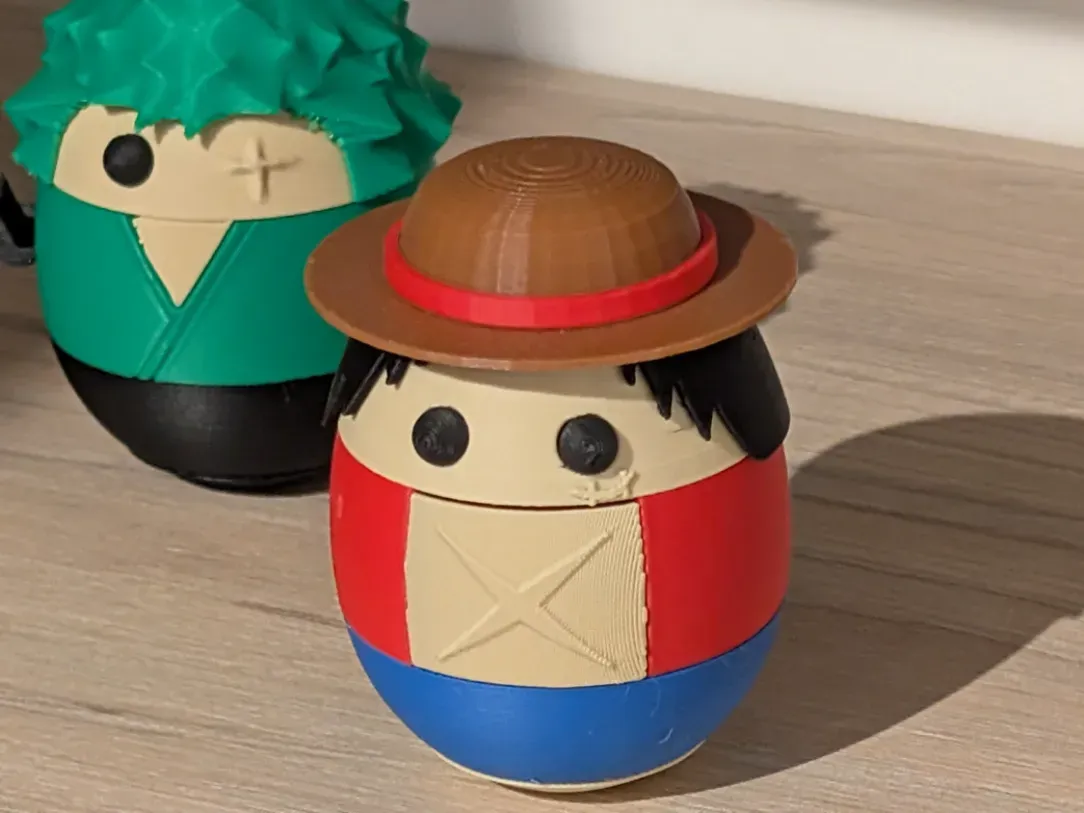 Egg-shaped figure of Luffy from One Piece, with a Zoro one in the background